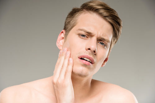 man examining skin man examining skin